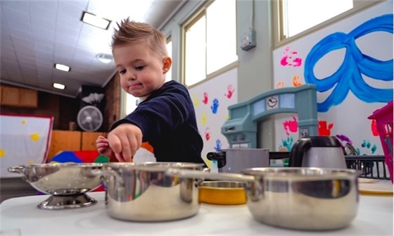 Child playing with pots and pans during Smart Start program
