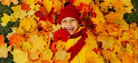 Girl smiling in pile of leaves