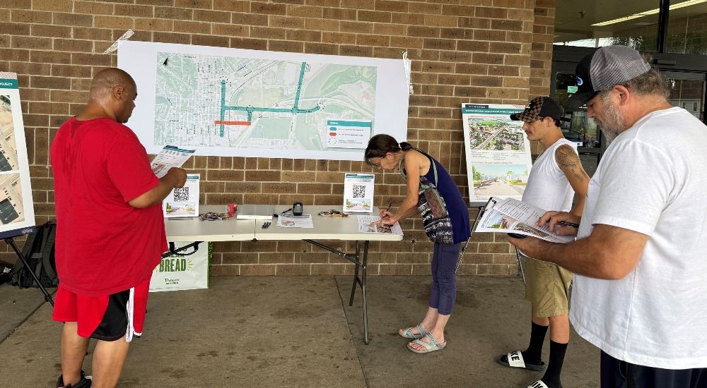 residents looking at B2E2 information outside a building