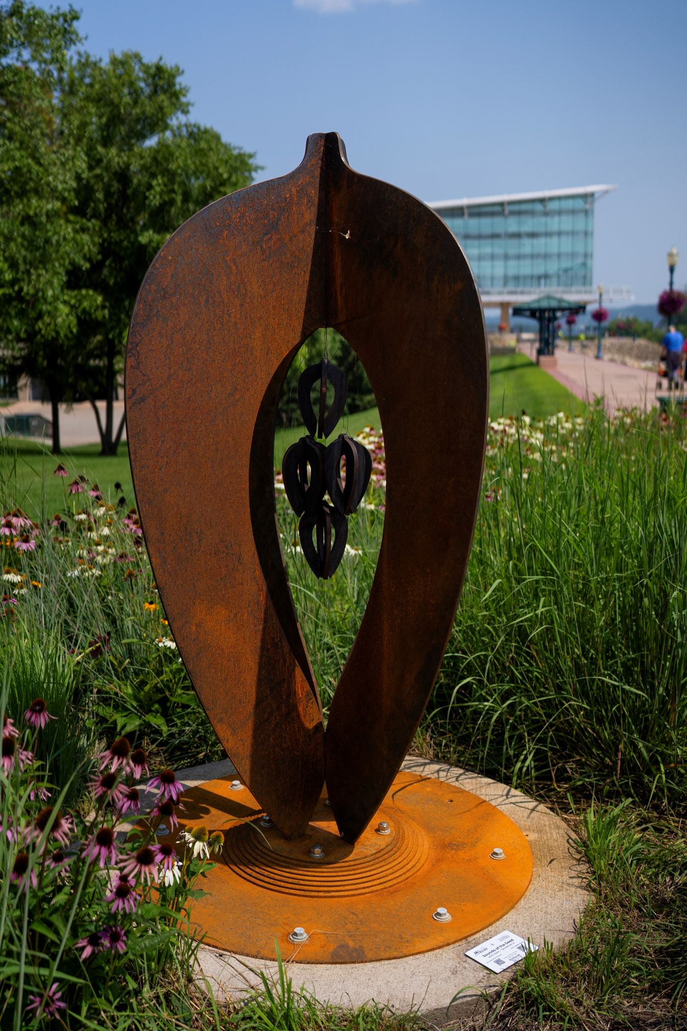 Large seed sculpture with a cluster of hanging wooden spheres at the center