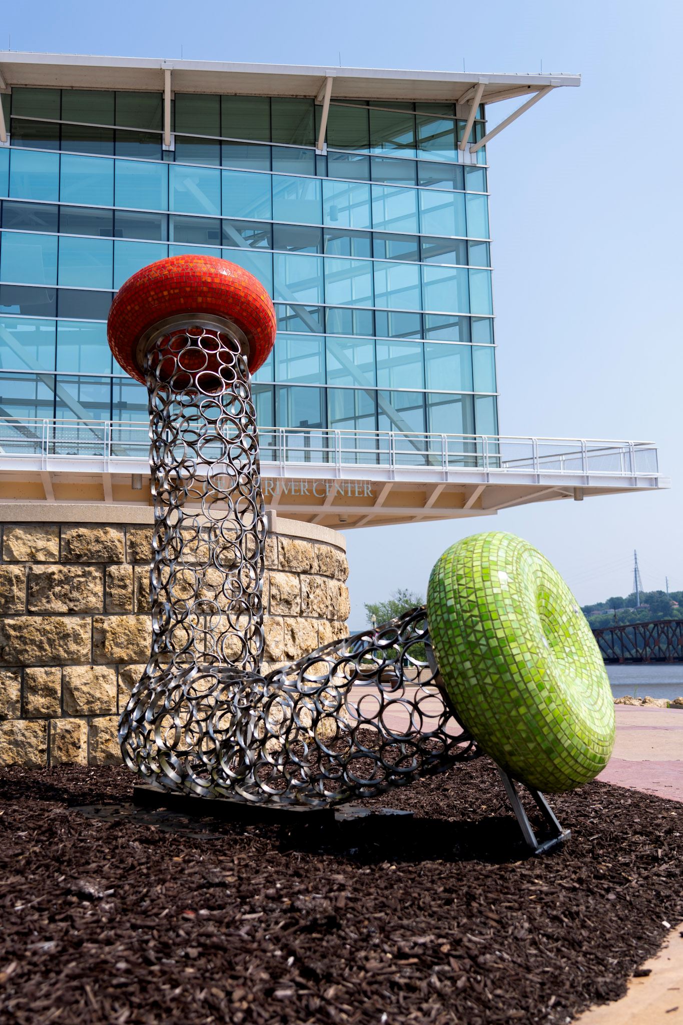 Tube-like sculpture with a red and a green mosaic cap at the ends